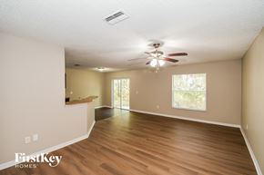 Starke house for rent - A spacious room with a ceiling fan and sliding glass doors.