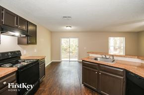 Starke house for rent - A kitchen with dark wood cabinets and a black stove top oven.