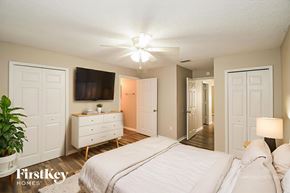 Starke house for rent - A bedroom with a bed, dresser, and mirror.