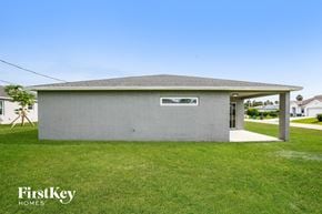 Port St. Lucie house for rent - A grey building with a FirstKey HOMES sign in front of it.