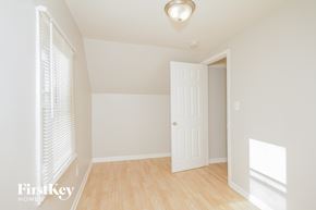Midlothian house for rent - a bedroom with white walls and a white door and wood floors