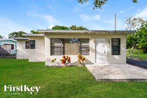 Fort Lauderdale house for rent - A white house with a green lawn in front of it.