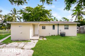 Fort Lauderdale house for rent - A small house with a white exterior and a green lawn in front.