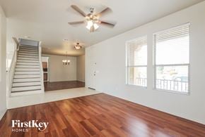 Surprise house for rent - an empty living room with a staircase and a ceiling fan