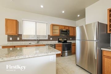 Surprise house for rent - a kitchen with granite counter tops and stainless steel appliances