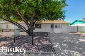 Phoenix house for rent - a white house with a tree and a parking lot