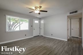 Phoenix house for rent - an empty living room with a ceiling fan and a window