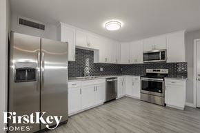 Phoenix house for rent - a white kitchen with stainless steel appliances and white cabinets