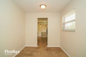 Indianapolis house for rent - A room with a carpeted floor and a window with blinds.