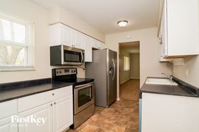 Indianapolis house for rent - A kitchen with a black counter top and white cabinets.