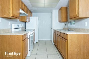 Port Charlotte house for rent - A kitchen with wooden cabinets and a white refrigerator.