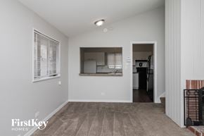 Dolton house for rent - an empty living room with a kitchen in the background