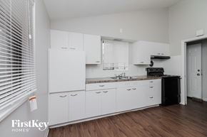 Dolton house for rent - a kitchen with white cabinets and a sink and a window