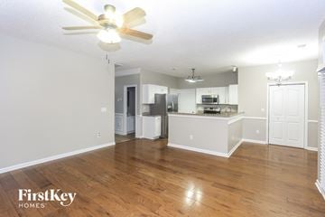 Huntersville house for rent - A spacious kitchen and living room with wooden floors and white walls.
