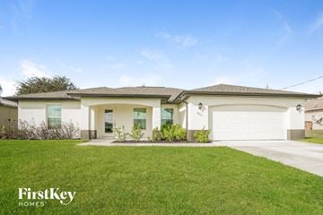 Cape Coral house for rent - a house with a lawn and a garage door