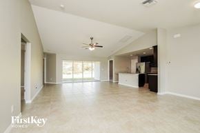 Cape Coral house for rent - an empty living room and kitchen with a ceiling fan