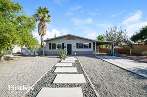Tempe house for rent - A house with a gravel driveway and a palm tree in the background.
