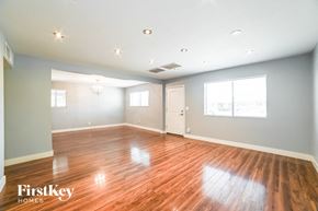 Tempe house for rent - A spacious room with wooden floors and white walls.