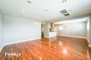 Tempe house for rent - A spacious room with wooden floors and a white ceiling with lights.