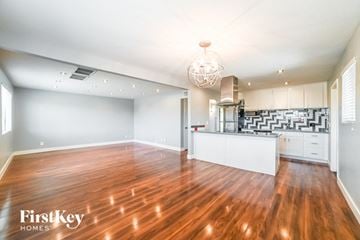 Tempe house for rent - A spacious kitchen and living room with wooden floors and white walls.