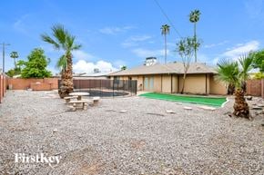 Mesa house for rent - A house with a gravel yard and palm trees.