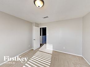 Cypress house for rent - a spacious living room with carpeted flooring and a white door to a hallway