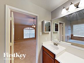 Cypress house for rent - a bathroom with a sink and a mirror and a door to a bedroom