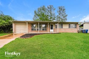 Florissant house for rent - A house with a garage and a tree in front of it.