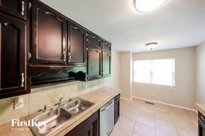 Birmingham house for rent - a kitchen with dark wood cabinets and a stainless steel sink