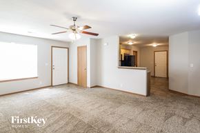 Pleasant Hill house for rent - an empty living room with a ceiling fan and a kitchen