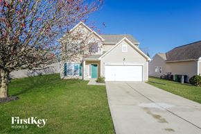 Charlotte house for rent - a white house with a white garage door and a lawn
