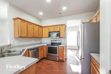 Charlotte house for rent - a kitchen with wooden cabinets and stainless steel appliances