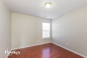 Charlotte house for rent - a bedroom with white walls and wood floors and a window