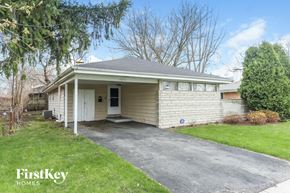 Dolton house for rent - the front of a white house with a driveway and a tree