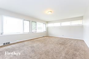 Dolton house for rent - a living room with a carpeted floor and three windows