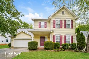 Huntersville house for rent - a yellow house with red shutters and a white garage