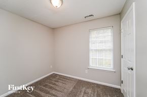 Huntersville house for rent - the bedroom of an apartment with carpeted flooring and a window