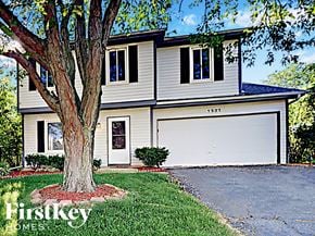Aurora house for rent - A two-story house with a garage and a tree in front.