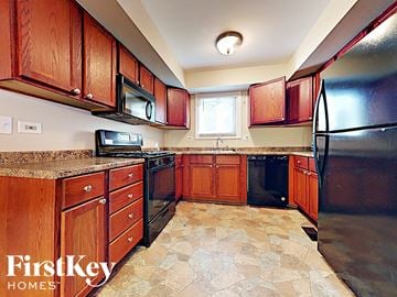 Aurora house for rent - A kitchen with wooden cabinets and black appliances.