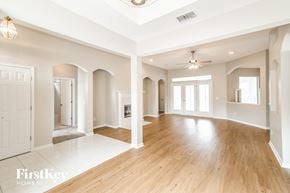 Fleming Island house for rent - A spacious room with wooden floors and white walls.