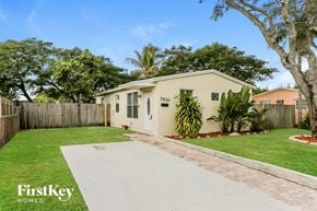 Hollywood house for rent - a white house with a yard and a sidewalk and a fence