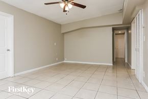 Fort Lauderdale house for rent - an empty living room with a ceiling fan and tiled floor