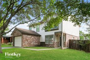San Antonio house for rent - A house with a white exterior and a brown roof is surrounded by a wooden fence.