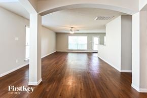 Houston house for rent - an empty living room with wood floors and a ceiling fan