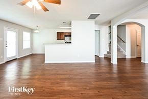 Houston house for rent - an empty living room with wood flooring and a kitchen