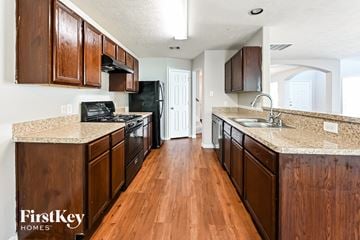 Houston house for rent - a kitchen with wood flooring and granite counter tops and