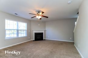 Rural Hall house for rent - A spacious room with a fireplace and a ceiling fan.