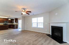 Rural Hall house for rent - A spacious living room with a fireplace and a ceiling fan.