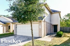 Houston house for rent - a house with a white garage door and a tree