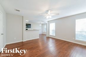 Houston house for rent - an empty living room with wood flooring and a ceiling fan